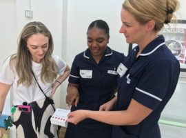 Miss Amber Jones looking at a blood test card with staff.