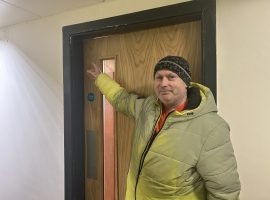 Graeme, resident of Malus Court showing the faulty fire door